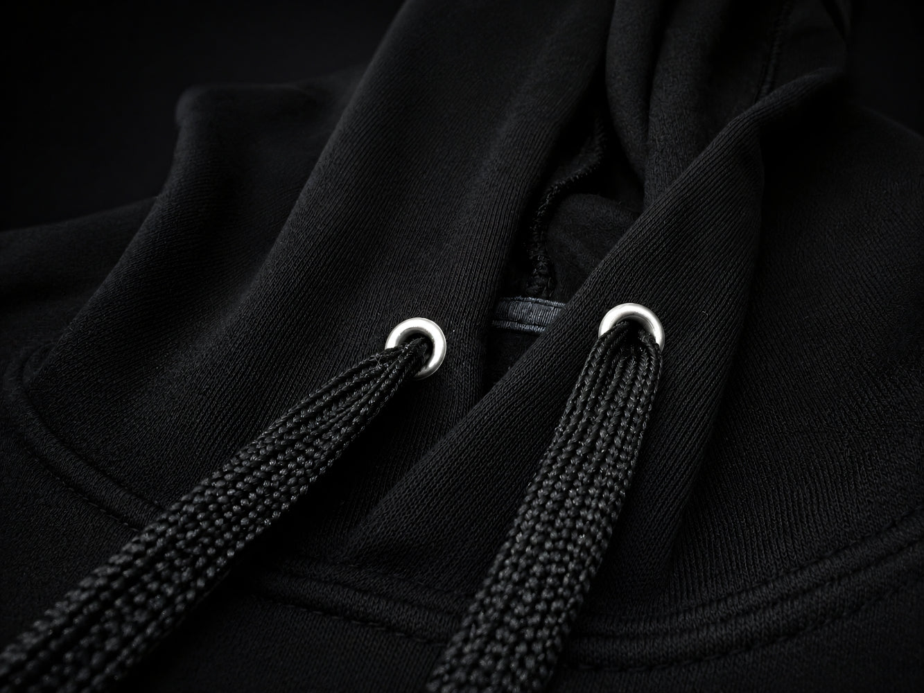 Close-up of Valhalla black hoodie with drawstrings on a dark background