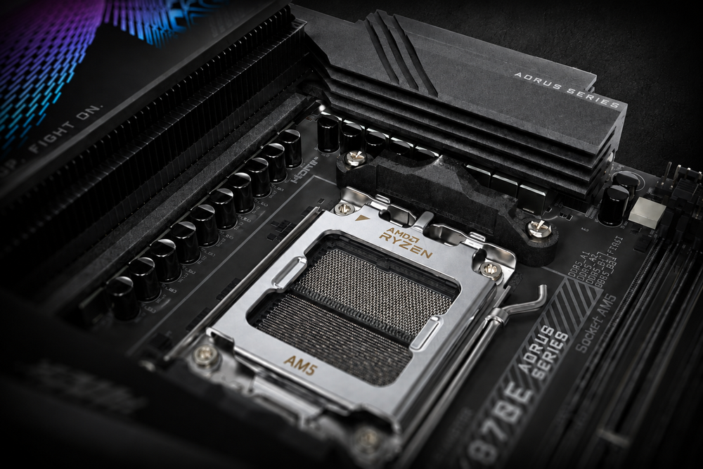 Close-up of an AM5 motherboard VRM heatsink and power delivery area next to the AMD Ryzen CPU socket.