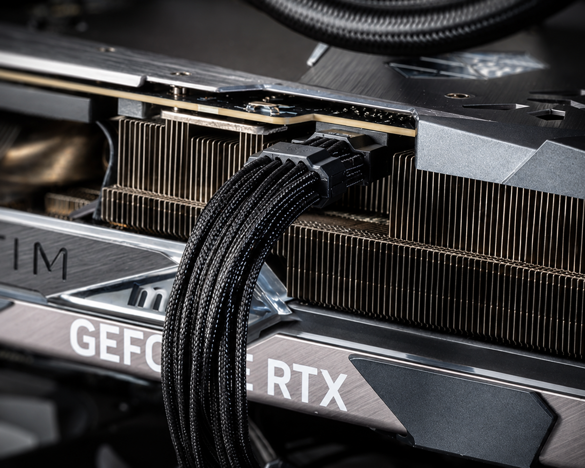 Close-up of an RTX 5090 12V-2x6 GPU power connector and braided power cable inside a high-end gaming PC.