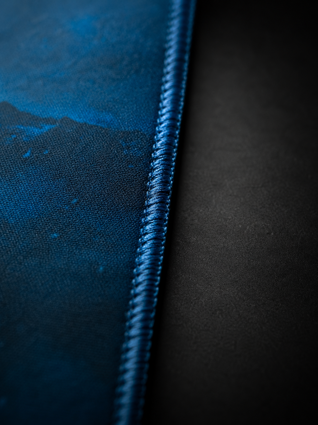 Valhalla XL gaming mousepad close-up showing textured rubber backing, reinforced stitched edge, 3mm thickness, and smooth gaming surface detail