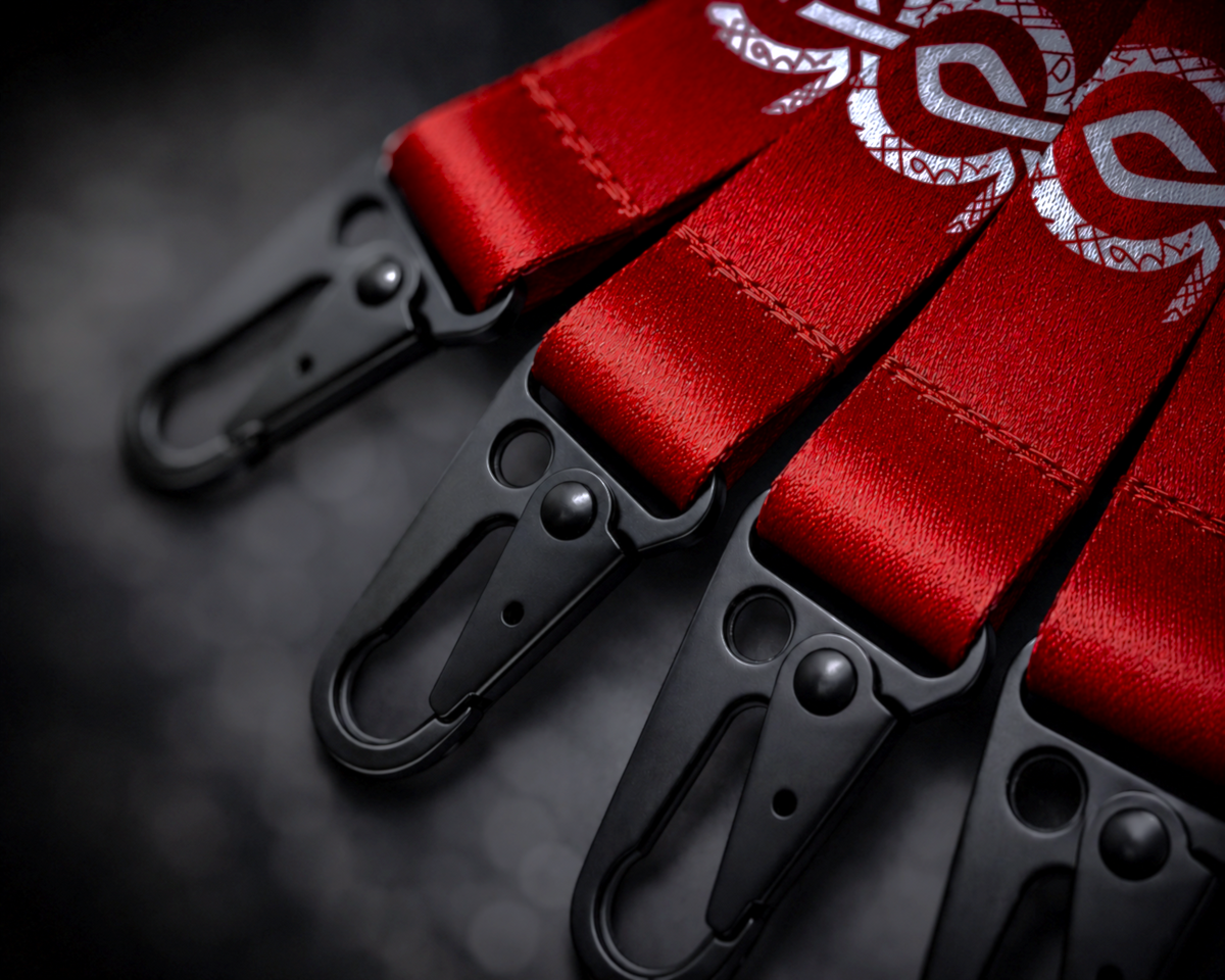 Valhalla Forge Your Legacy premium woven lanyard close-up with red fabric, black metal clasp hardware, textured strap detail, and branded custom gaming PC merchandise for Valhalla Performance PC.